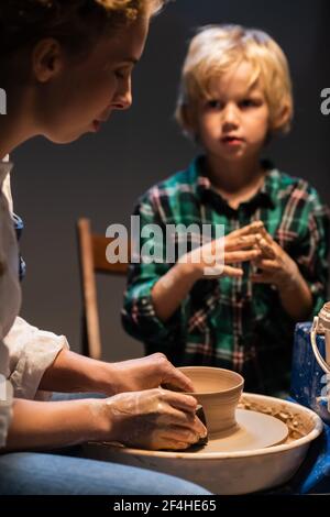 the older sister and her younger brother spend time in a pottery workshop, making clay dishes. Stock Photo