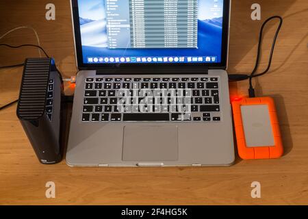 Laptop computer with two different external hard drives attached. Backing up data. Stock Photo