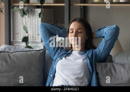 Close up peaceful woman with closed eyes relaxing on couch Stock Photo