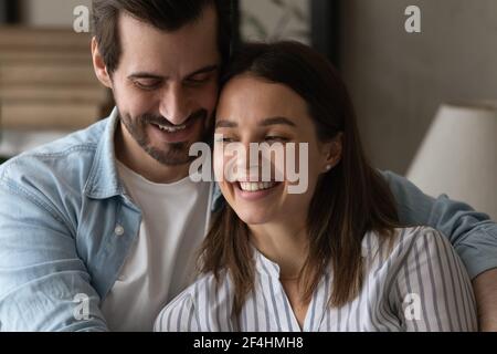 Close up overjoyed man and woman hugging, having fun Stock Photo