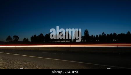 Light trail and Tuggeranong parkway highway in Canberra from the side of the road Stock Photo