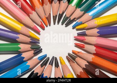 Colourful children's drawing pencil pointing one another in a circle and making a circular pattern with a placeholder in the middle Stock Photo