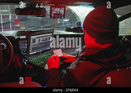 A Detroit police officer chercks a persons drivers licence, Detroit, Michigan, USA Stock Photo