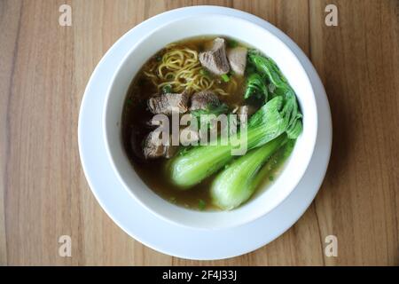 Chinese noodles with pork on wood background Stock Photo