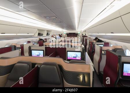 Qatar Airways QSuites cabin on Airbus A350. QSuite is a premium business class seat with doors introduced by Qatar Airways. Boarding at Doha, Qatar.