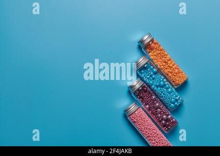 jars and colored balls on a blue background Stock Photo