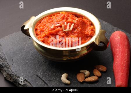 Gajar ka halwa is a carrot-based sweet dessert pudding from India. Garnished with Cashew almond nuts and Served in bowl. Stock Photo