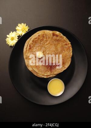 Puran Poli, also known as Holige, is an Indian sweet flatbread from India consumed mostly during Holi festival. Served in a plate with pure Ghee. Stock Photo