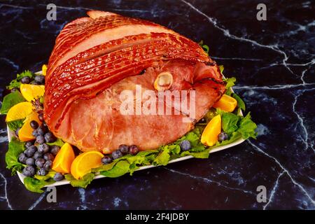 Smoked whole pork ham with fresh fruits. Healthy food. Stock Photo
