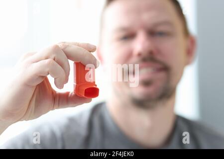 Man holds an inhaler in his hand. Stock Photo