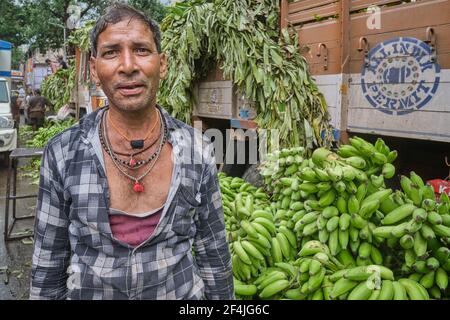 An employee of a transport company standing next to his truck and a delivery of bananas at Matunga Market in Mumbai, India Stock Photo