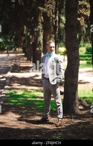 Groom at wedding tuxedo smiling and waiting for bride. Rich groom at wedding day. Elegant groom in costume and bow-tie. Stock Photo