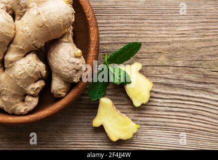 Bowl with fresh ginger on wooden table Stock Photo