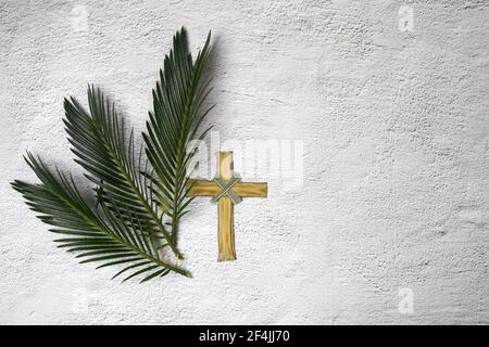 Palm sunday background. Cross and palm on grey background. Stock Photo