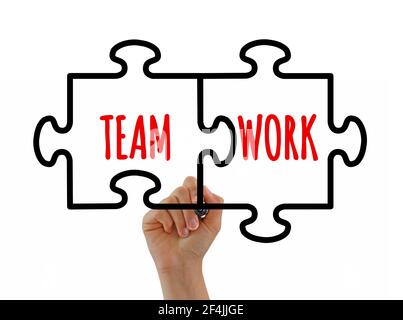 Hand sketching teamwork jigsaw puzzle pieces concept with black marker on transparent glass board or white background. Teamwork success concept. Stock Photo