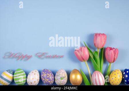 Pink tulips flowers and colourful eggs on pink background. Card for Happy Easter. Waiting for spring. Greeting card. Hello spring and easter concept. Stock Photo