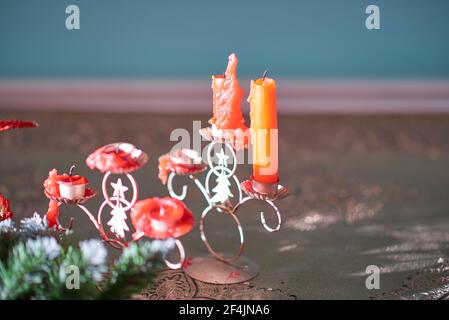 Stubs of red candles on a figured Christmas candlestick with a picture of a fir. The holiday is over Stock Photo
