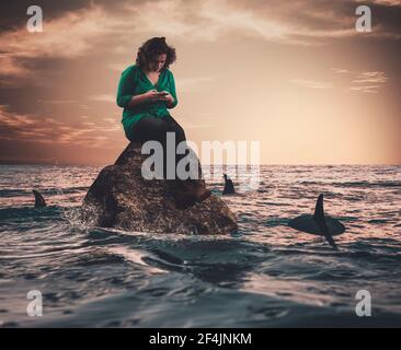 Young woman on a rock in the sea surrounded by sharks .Careless sitting on rock under threat.