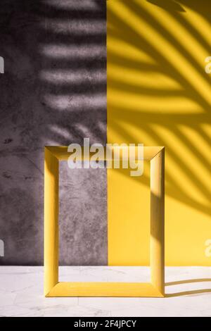 Abstract shadows on a gray-yellow background for the sale of a cosmetic product, a cosmetic showcase in a minimalist style. Stock Photo