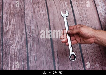 a wrench with ratchet in a man's hand.  Stock Photo