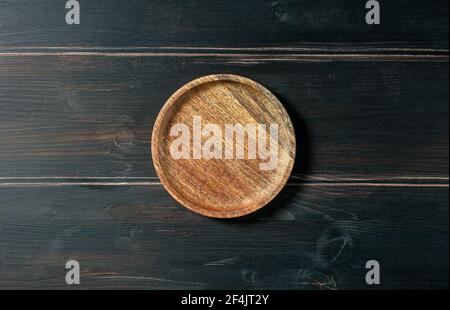 empty wooden plate on dark kitchen table, top view Stock Photo