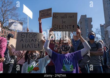 NEW YORK, NY - MARCH 21: Children hold signs that reads 'stop Asian hate' and 'we will not be silent!' at a rally against hate in Columbus Park in the Chinatown neighborhood of Manhattan on March 21, 2021 in New York City. A rally for solidarity was organized in response to a rise in hate crimes against the Asian community since the start of the coronavirus (COVID-19) pandemic in 2020. On March 16 in Atlanta, Georgia, a man went on a shooting spree in three spas that left eight people dead, including six Asian women.Protesters hold placards during a rally against hate in Columbus Park in the C Stock Photo