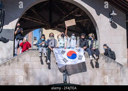 Protesters sit in on a structure over looking the park with a sign that says Stop Hating Asians and Korean flag during a rally against hate in Columbus Park in the Chinatown neighbourhood of Manhattan in New York City.A rally for solidarity was organized in response to a rise in hate crimes against the Asian community since the start of the coronavirus (COVID-19) pandemic in 2020. On March 16 in Atlanta, Georgia, a man went on a shooting spree in three spas that left eight people dead, including six Asian women. (Photo by Ron Adar/SOPA Images/Sipa USA) Stock Photo