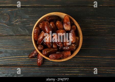 Bowl with dried dates on a wooden table, rustic natural sweet snack from above Stock Photo