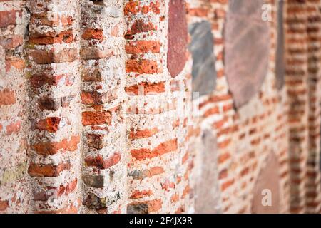 Perspective selective focus red brick wall texture background. Ancient masonry of brick and stone thousand years wall of St Boris and Gleb or Stock Photo