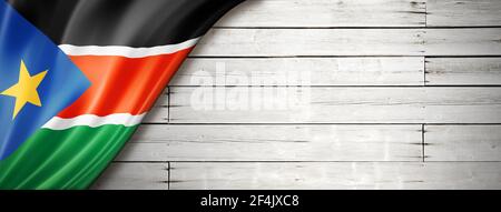 South Sudan flag on old white wall. Horizontal panoramic banner. Stock Photo