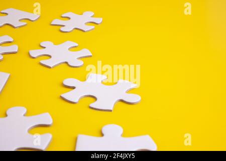 white puzzles isolated on yellow Stock Photo