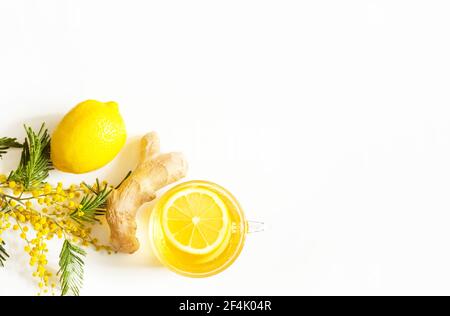 Herbal tea in a cup, ginger, lemon and acacia - strengthen immune system in the cold season. Allergies, fever, flu. Vitamin drink for health and ingre Stock Photo