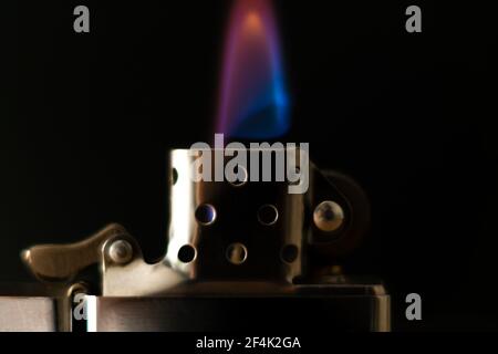 Close-up of a burning zippo lighter on a black background, macro Stock Photo