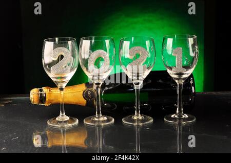 New Year 2021 on wine glasses near a champagne bottle Stock Photo