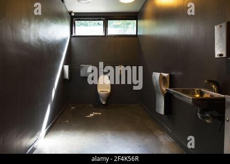 Toilet paper on floor in a dirty bathroom Stock Photo