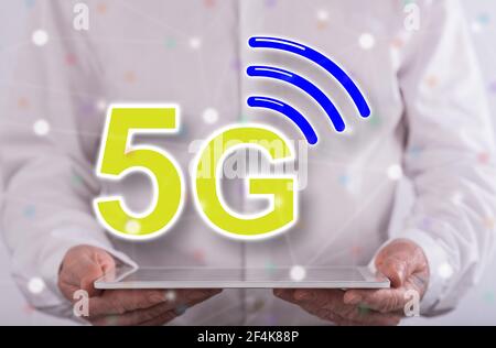 5g concept above a tablet held by a man in background Stock Photo