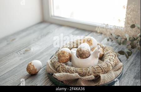 Easter still life with decorated Easter eggs and decorative nest on a wooden surface. Happy Easter wishes concept. Stock Photo