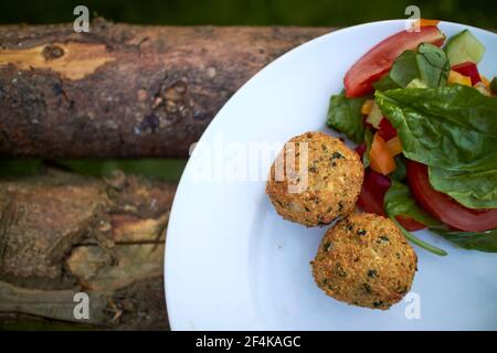 meatballs and vegetables on a plate outdoors Stock Photo