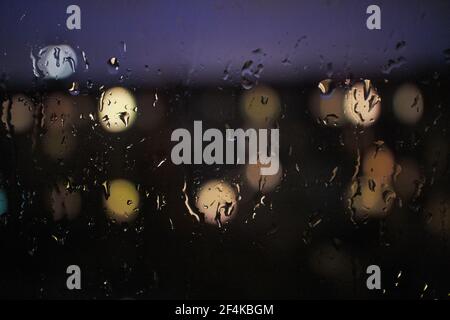 raindrops on a window at night time Stock Photo