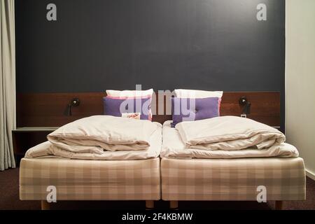 two small beds in a cozy hotel room Stock Photo