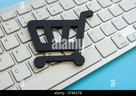 Shopping cart on the keyboard as symbol of online e-commerce. Stock Photo