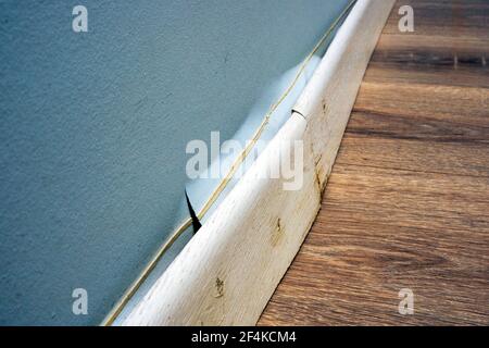 Damaged skirting board detached from the wall after the apartment was flooded. Stock Photo