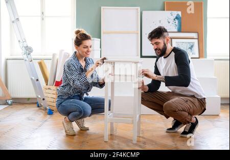 Mid adults couple renovating furniture indoors at home, relocation and diy concept. Stock Photo