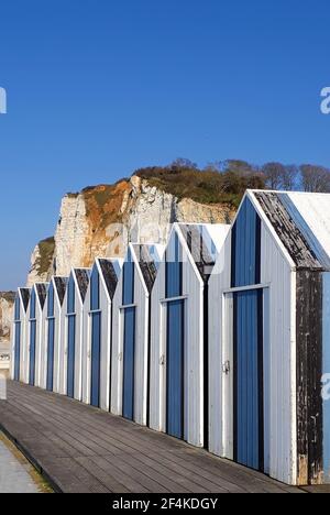 Vacation in Yport with blue and white fishermen's huts on the beach and cliffs in the background Stock Photo