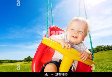 Photo of the little boy on swings in park Stock Photo