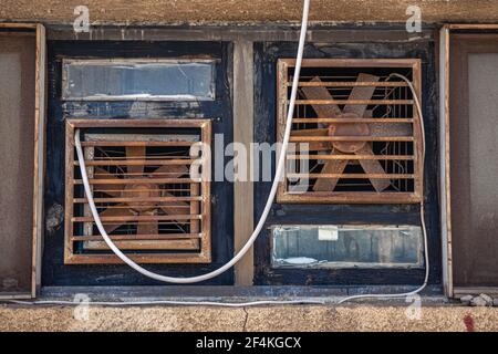 Close up of rusty dirty metal ventilation fan of old air conditioning system on house front. Stock Photo