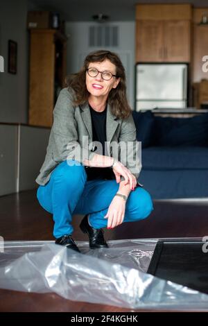 Peekskill, New York, USA. Female artist, Melinda Hunt, showing the artwork on her Hart Island Project, while giving an interview inside her studio. Stock Photo