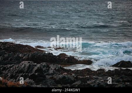 close up of strong waves in the ocean hitting rocks Stock Photo