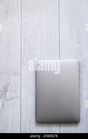 A lap top on a white timber - desktop or flooring, copy space, cut out, from above, metal, zinc, no people Stock Photo