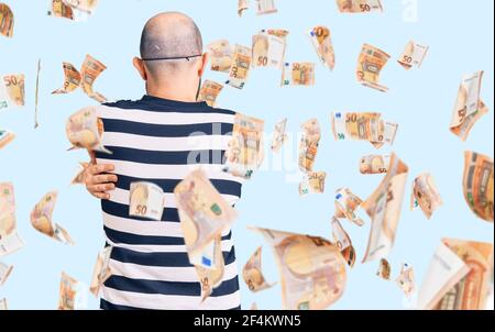 Young handsome man wearing burglar mask hugging oneself happy and positive from backwards. self love and self care Stock Photo